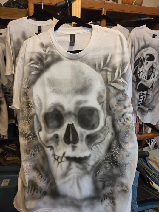 Hand-airbrushed black and white skull framed by a fern and botanical wreath on a white XL Gildan t-shirt, goth botanical one-of-a-kind