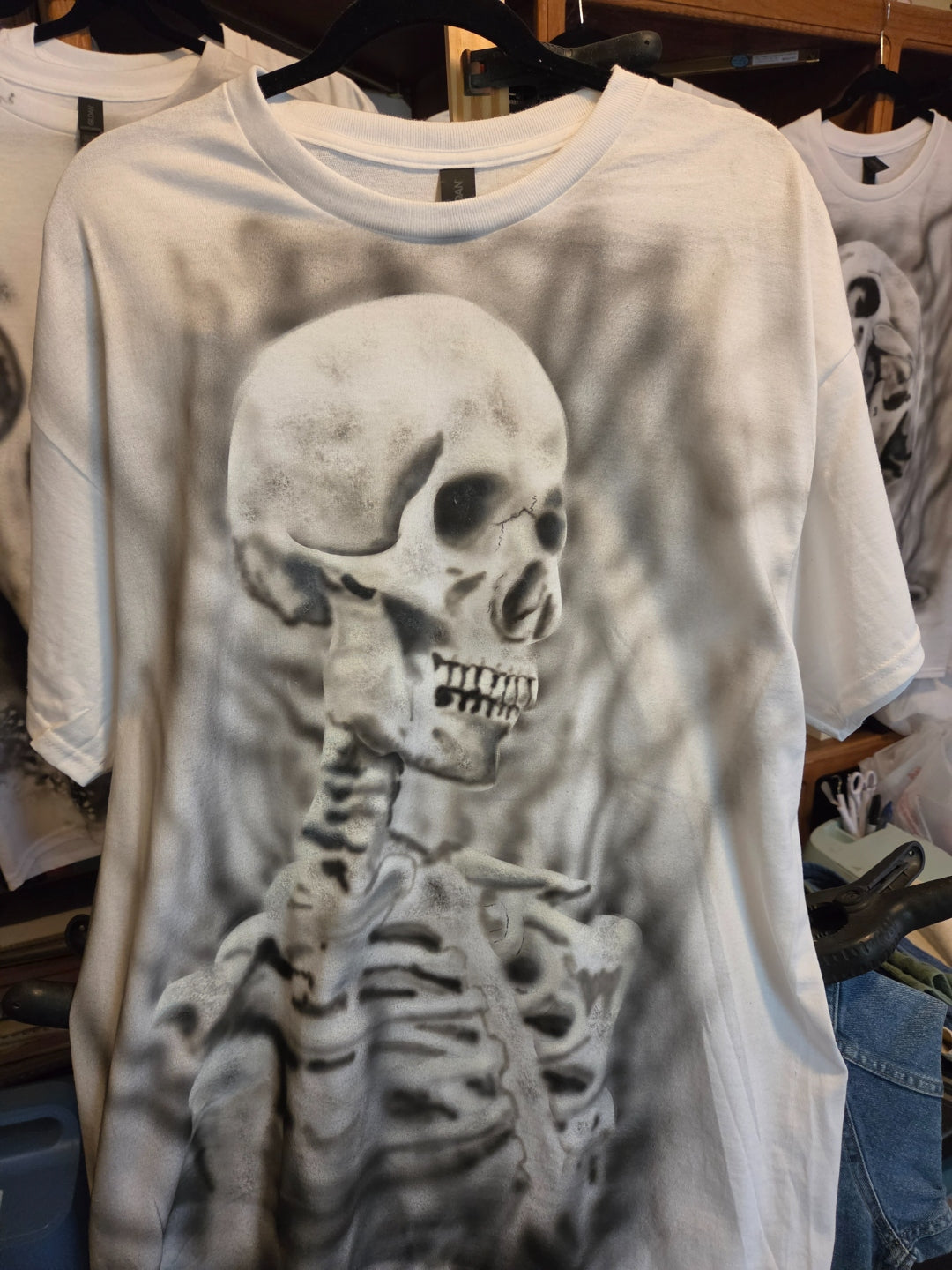 Hand-airbrushed black and white skeleton profile with skull, spine and ribcage on a white XL Gildan t-shirt, metal streetwear one-of-a-kind