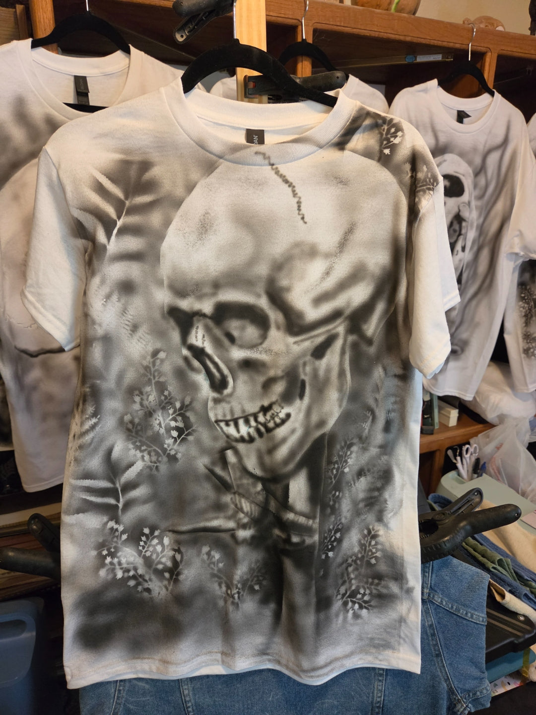 Hand-airbrushed black and white skull surrounded by wildflowers and ferns on a white size Small Gildan t-shirt, goth botanical one-of-a-kind