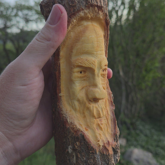 Turning video of a hand-carved cottonwood wood spirit face carving held in hand outdoors in High Rolls, New Mexico