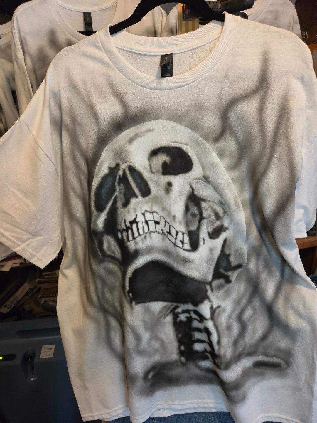 Hand-airbrushed black and white screaming skull with exposed spine and smoke wisps on a white XL Gildan t-shirt, punk metal one-of-a-kind