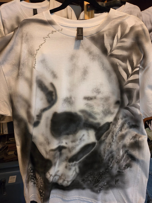 Hand-airbrushed black and white skull with fern and floral accents on a white XL Gildan t-shirt, goth streetwear one-of-a-kind
